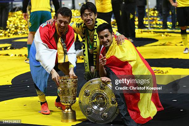 Ivan Perisic, Shinji Kagawa and Ilkay Guendogan of Dortmund pose with the trophies after winning the DFB Cup final match between Borussia Dortmund...