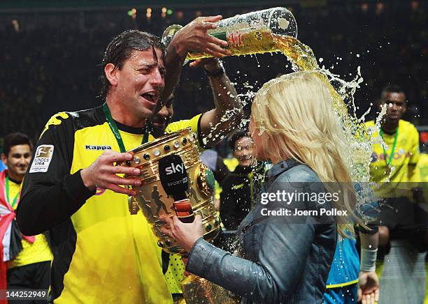 Sport reporter Jessica Kastrop of sky television channel gets a beer shower from Mitchell Langerak after the DFB Cup final match between Borussia...