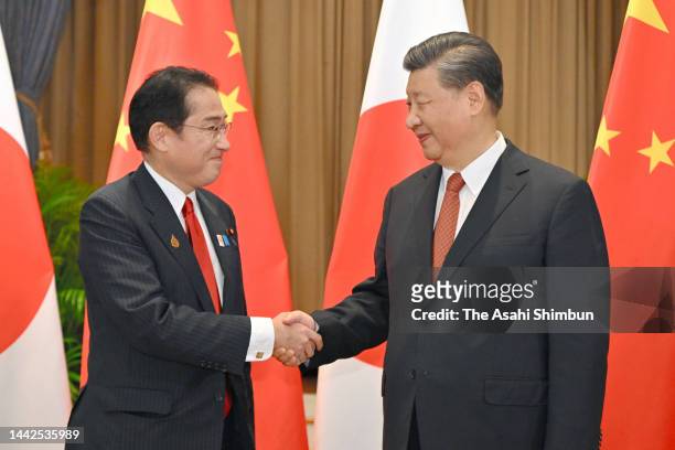 Japanese Prime Minister Fumio Kishida and Chinese President Xi Jinping shake hands prior to their bilateral meeting on November 17, 2022 in Bangkok,...