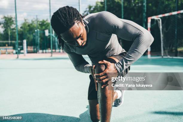 active sportsman having a knee pain during training - inflamação imagens e fotografias de stock