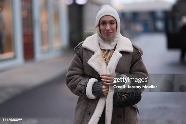 Sonia Lyson is seen wearing Gobi Cashmere grey sweater, Twenty Fall leather coat, Miu Miu bag and & Other Stories creme white wool balaklava, on...