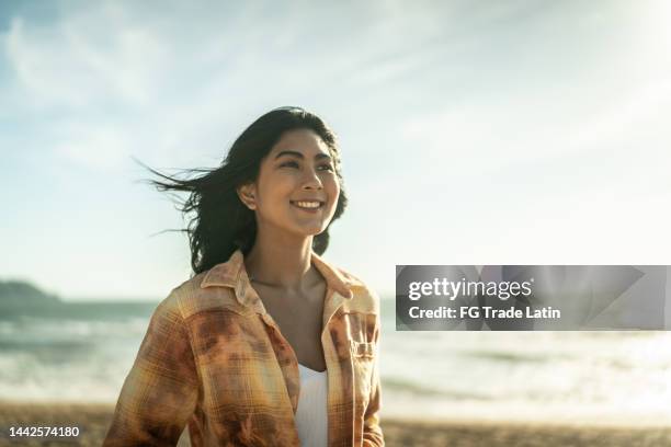 young women contemplating at the beach - one young woman only health hopeful stock pictures, royalty-free photos & images