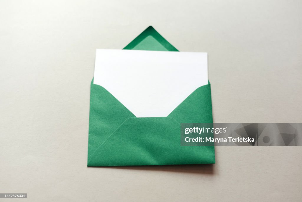 Green envelope with a white sheet on a gray background. Wish list. New Year. Christmas.