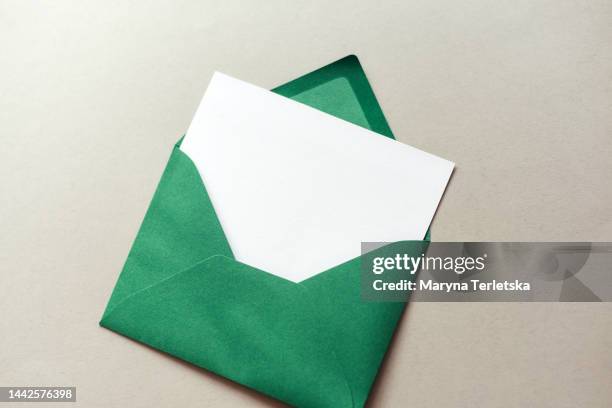 green envelope with a white sheet on a gray background. wish list. new year. christmas. - flatlay stock-fotos und bilder