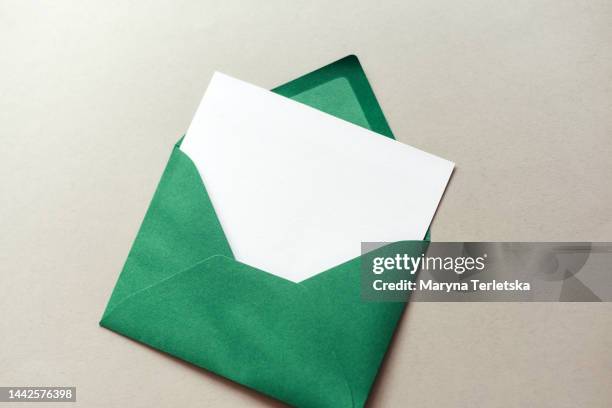green envelope with a white sheet on a gray background. wish list. new year. christmas. - message stock pictures, royalty-free photos & images
