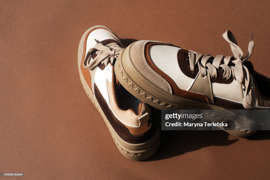 Sneakers in brown tones on a brown background. Stylish women's shoes. Keds. Part of a fashionable image.