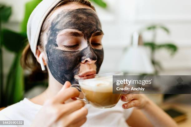 young woman enjoying her cup of coffee - femininity stock pictures, royalty-free photos & images