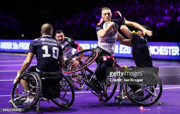 Jack Brown of England is tackled by Nicolas Clausells and Florian Guttadoro of France during the Wheelchair Rugby League World Cup Final match...
