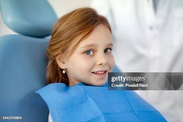 child looking at camera at dentist - tandfyllning bildbanksfoton och bilder