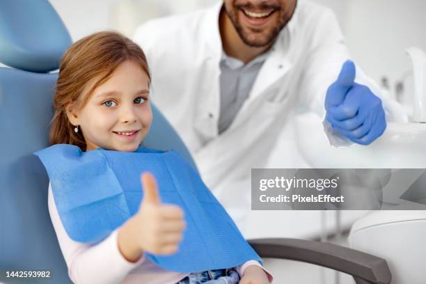 child with dentist shows thumb up - pediatric dentistry stock pictures, royalty-free photos & images