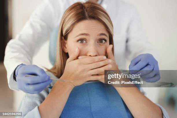woman at dental practice refusing dentist treatment - bang stockfoto's en -beelden