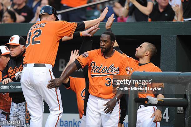 Matt Wieters of the Baltimore Orioles celebrates scoring teams second run with Bill Hall and Nick Markakis during a baseball game against the Tampa...