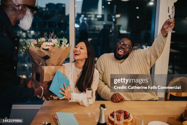 a happy woman is presented with a bouquet of flowers at an after-work office party - congratulating stock pictures, royalty-free photos & images