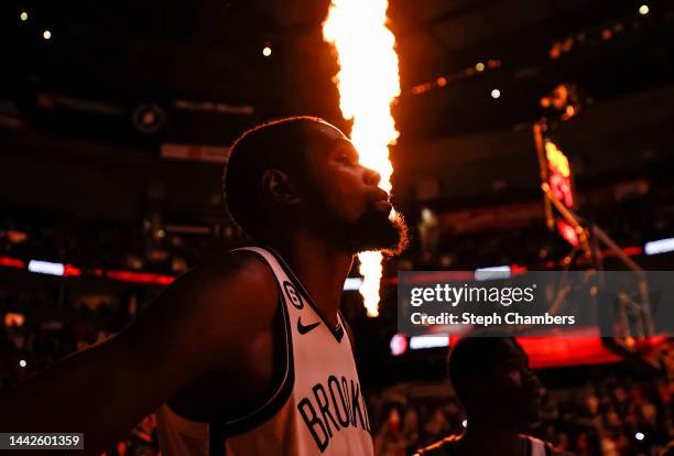 Flames erupt behind Kevin Durant of the Brooklyn Nets as he prepares to play Portland Trail Blazers at Moda Center on November 17, 2022 in Portland,...