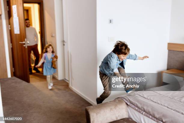 happy young family with two children entering room at luxury hotel - family holidays hotel stock pictures, royalty-free photos & images