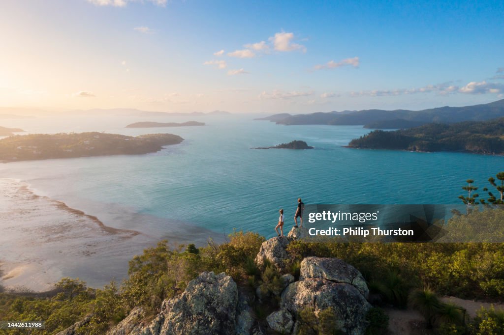 Couple enjoying the view on top mountain overlooking Whitsundays ocean