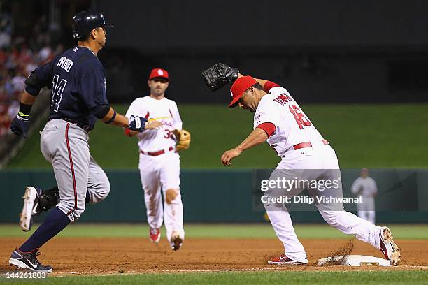 Reliever J.C. Romero of the St. Louis Cardinals beats Martin Prado of the Atlanta Braves to first base for an out at Busch Stadium on May 12, 2012 in...