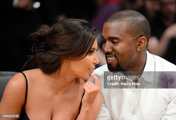Kim Kardashian and rapper Kanye West talk from their courtside seats before the Los Angeles Lakers take on the Denver Nuggets in Game Seven of the...