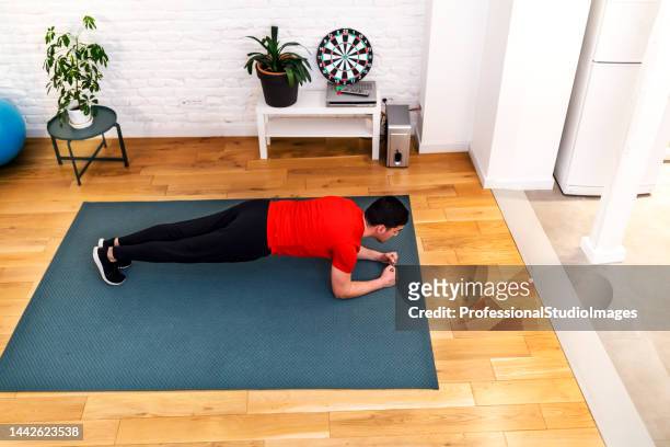 男性は家で腕立て伏せをして自宅でトレーニングをしています。 - professional sportsperson ストックフォトと画像