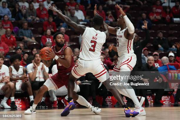 Damian Dunn of the Temple Owls tries to get out of the double team of Mawot Mag and Aundre Hyatt of the Rutgers Scarlet Knights during the second...