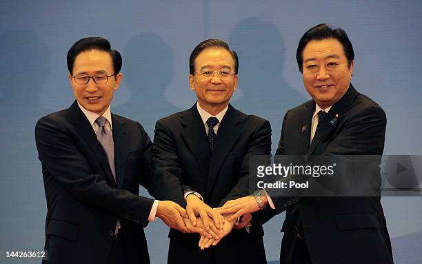 South Korean President Lee Myung-bak, China Premier Wen Jiabao and Japanese Prime Minister Yoshihiko Noda pose for photographs at the Great Hall of...