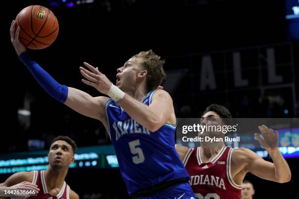 Adam Kunkel of the Xavier Musketeers attempts a layup while being guarded by Trey Galloway of the Indiana Hoosiers in the second half at the Cintas...