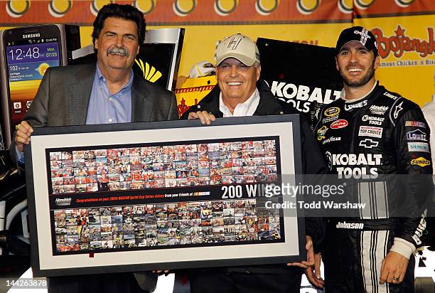 Jimmie Johnson, driver of the Lowe's/Kobalt Tools Chevrolet, celebrates in Victory Lane with team owner Rick Hendrick and NASCAR President Mike...