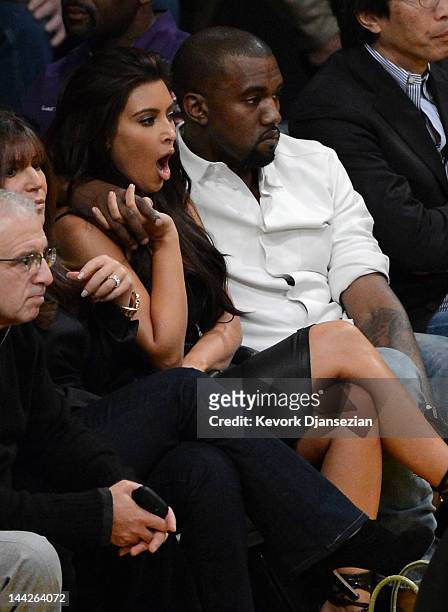 Kanye West puts his arm around Kim Kardashian from their courtside seats as the Los Angeles Lakers take on the Denver Nuggets in Game Seven of the...