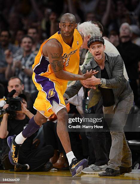 Kobe Bryant of the Los Angeles Lakers reacts with Justin Timberlake after Bryant makes a basket in the fourth quarter against the Denver Nuggets in...