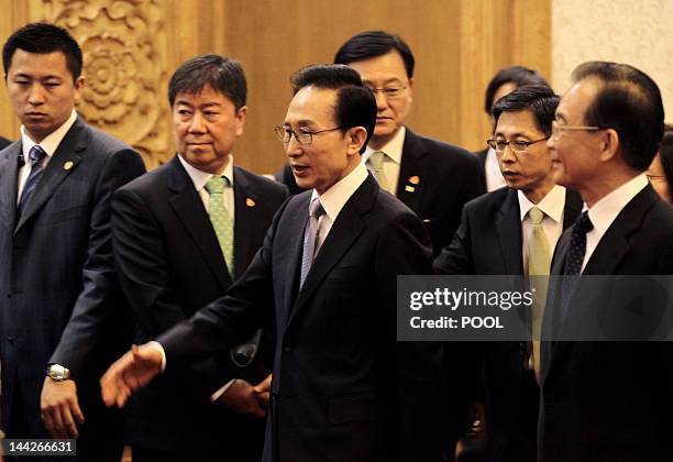 South Korea's President Lee Myung-bak walks with China's Premier Wen Jiabao to a joint news conference of the fifth trilateral summit among China,...