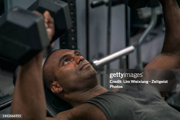 nahaufnahme eines indischen bodybuilders, der gewichte hebt - body men close up stock-fotos und bilder