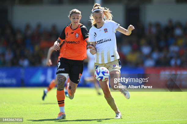 Larissa Crummer of the Roar and Emily Garnier of Newcastle compete for the ball during the round one A-League Women's match between the Brisbane Roar...