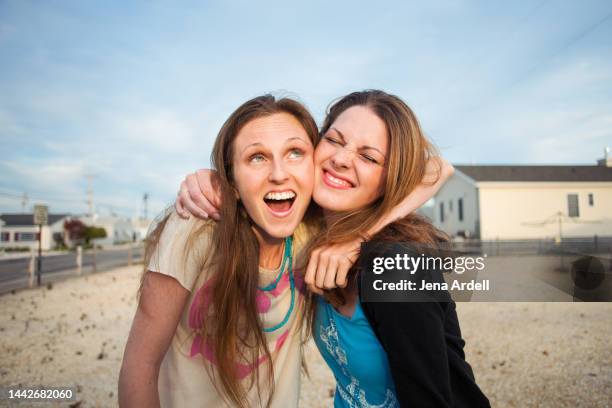 best friends having fun outside, funny friends embracing, two female friends - wange an wange stock-fotos und bilder