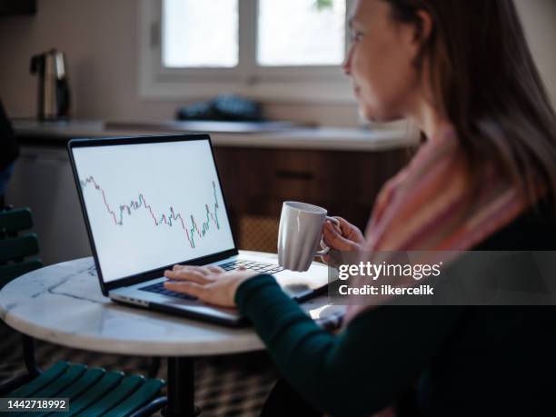 mujer emprendedora revisando su inversión en el mercado de valores usando una computadora portátil - etf fotografías e imágenes de stock