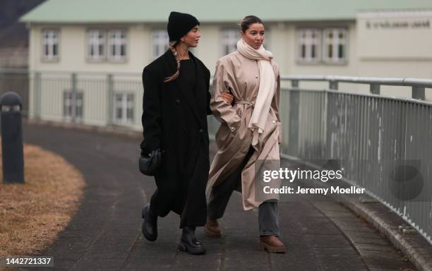 Bruna Rizk is seen wearing black Source Unknown coat, Bottega Veneta Mini Jodie black leather bag and Copenhagen Studios CPH145 boots; Benthe Liem is...