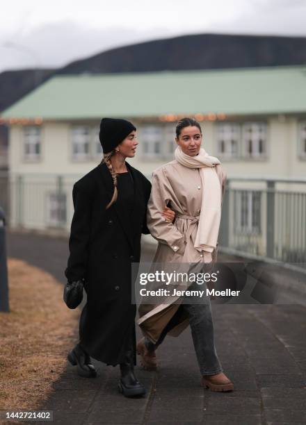 Bruna Rizk is seen wearing black Source Unknown coat, Bottega Veneta Mini Jodie black leather bag and Copenhagen Studios CPH145 boots; Benthe Liem is...