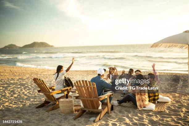 friends having a picnic toasting marshmallows at the beach - mexican picnic stock pictures, royalty-free photos & images