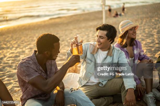 young friends making a toast at the beach - mexican picnic stock pictures, royalty-free photos & images