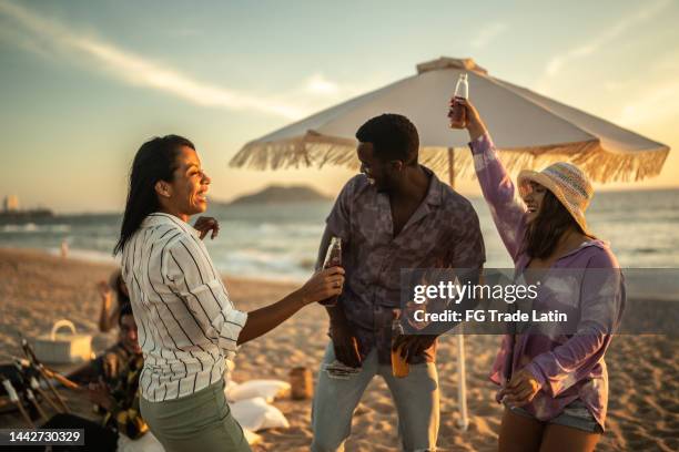 young friends having a party at the beach - mexican picnic stock pictures, royalty-free photos & images