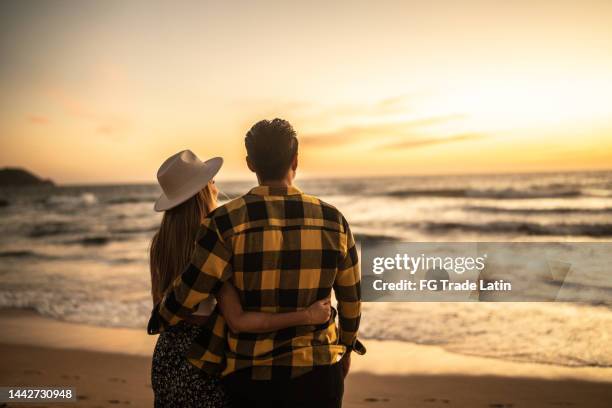 couple enjoying sunset at the beach - vapor da respiração imagens e fotografias de stock