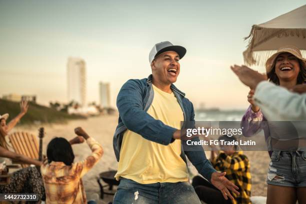 young friends dancing at the beach - tropical music stock pictures, royalty-free photos & images