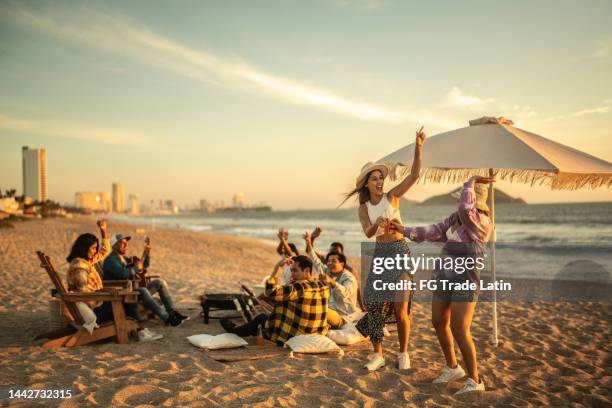 young friends having a party at the beach - latin american and hispanic ethnicity picnic stock pictures, royalty-free photos & images