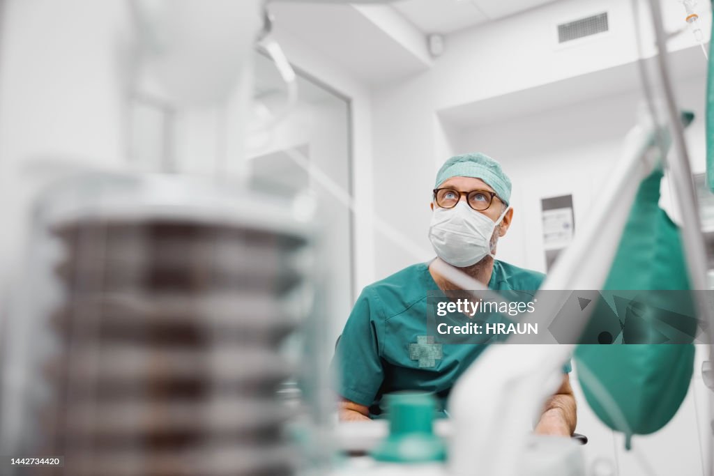 Männlicher Anästhesist im Operationssaal während der Operation