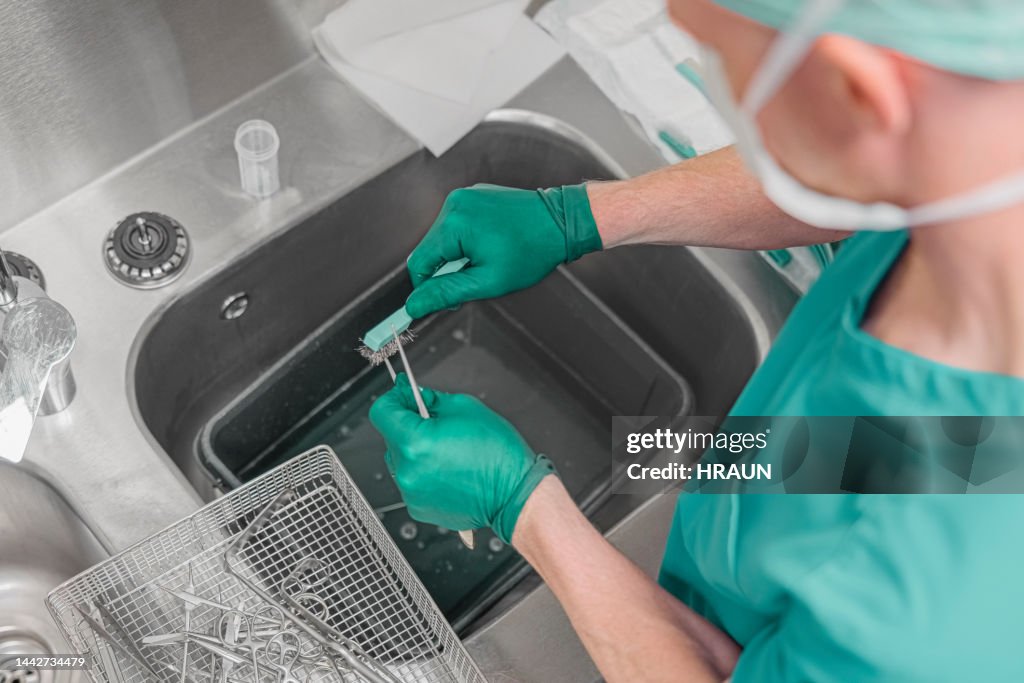 Nurse washing medical instruments after operation