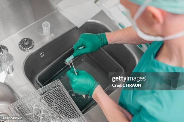 nurse washing medical instruments after operation - equipamento cirúrgico imagens e fotografias de stock