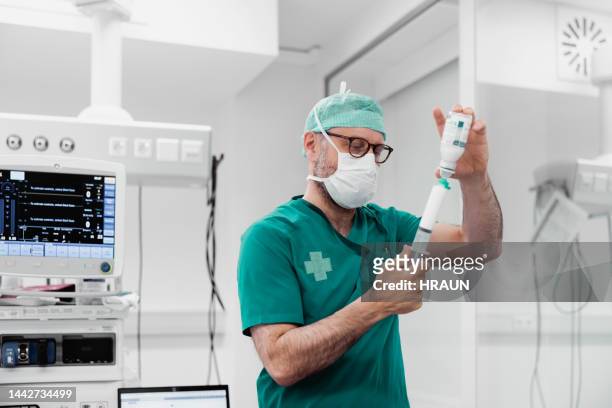 doctor preparing injection in operating room - verdovingsmiddel stockfoto's en -beelden