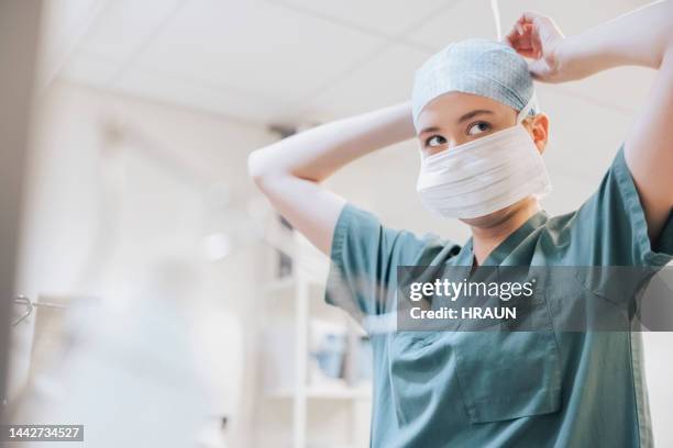 krankenschwester mit op-maske im operationssaal - chirurgenkappe stock-fotos und bilder