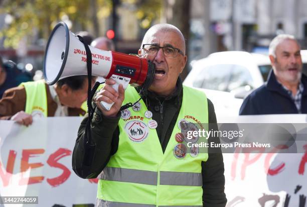 Man holds a megaphone at a demonstration to demand an improvement in pensions and wages in line with the real CPI, on 19 November, 2022 in Madrid,...