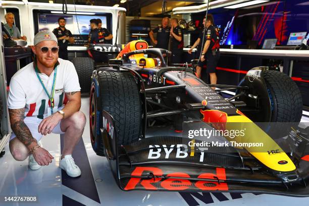 Ben Stokes poses for a photo next to the car of Max Verstappen of the Netherlands and Oracle Red Bull Racing during final practice ahead of the F1...