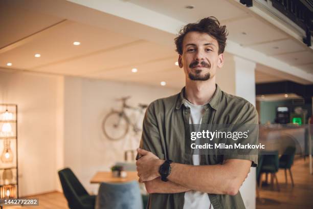 vue de face portrait d’un homme moderne debout, les bras croisés, regardant la caméra - hipster photos et images de collection
